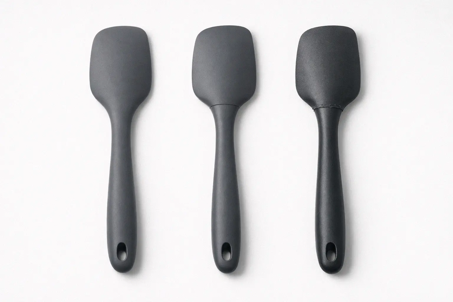 Quality comparison of three silicone kitchen spatulas from premium to budget showing construction differences