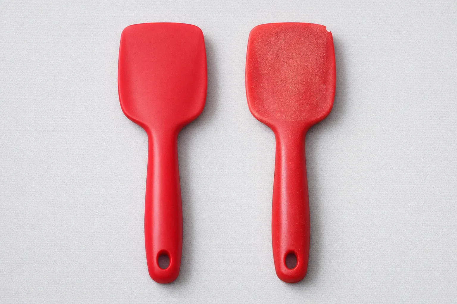 Side by side comparison of new silicone spatula and worn silicone spatula showing signs of aging discoloration and surface wear